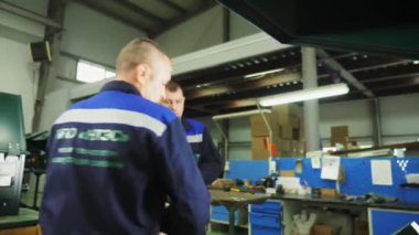 üniformalı işçiler dükkandaki makine aracına detay yüklerler