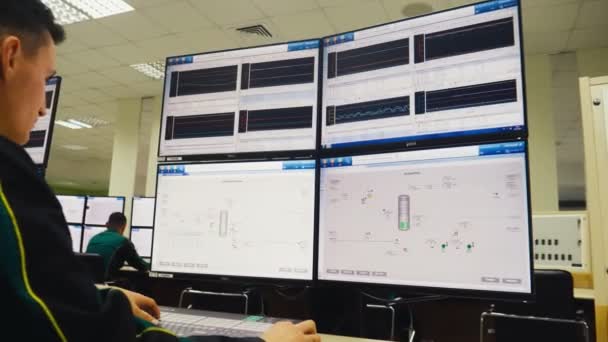 Ingeniero trabaja en un ordenador potente con monitores en la mesa — Vídeos de Stock