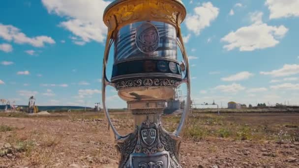 Retro cup met Yuri Gagarin portret tegen moderne pompjack — Stockvideo