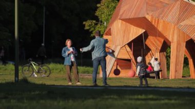 Küçük çocuklu aile uçurtması. Bahçede vakit geçiriyorlar.