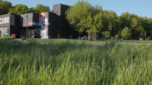 Mouvement sur la pelouse garçon à vélo le long de la piste près du club — Video