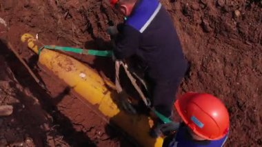İşçiler boruyu delikten geçirip hazırlıyorlar.