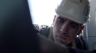 Meslektaşlarıyla birlikte beyaz kasklı jeologlar monitöre bakıyor.