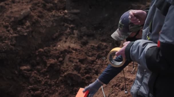 Arbeiter gibt Ingenieur im Schützengraben seismografischen Sensor — Stockvideo