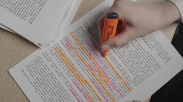女の子はオレンジのマーカーで文書の重要な部分をマーク — ストック動画