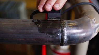İşçi işçileri borudaki dikişleri aşındırıcı jelle işliyor