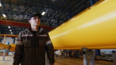 Gözlüklü işçiler sarı boru hattı boyunca yürür.