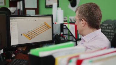 Mühendis ofisteki boru hattı sistemi çizimi üzerinde çalışıyor.