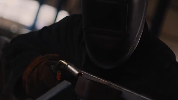 Мужчина работает с деталями и снимает защитную маску в магазине — стоковое видео