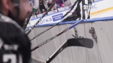 Sporcular buz arenasının yanında oturan sopalı çitleri vuruyor.