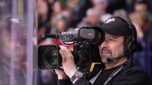 Volwassen cameraman schiet interessante hockey spel op ijsbaan — Stockvideo