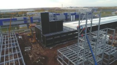 Atölye binasının yanında metal gövdeli vinçler var.