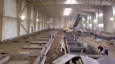 Kazı elemanı ve malzemelerle birlikte atölye boyunca hareket