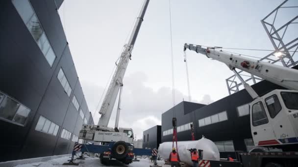 Dělnický tým ovládá zvedání obrovských detailů s jeřábem — Stock video