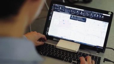 Mühendis dizüstü bilgisayardaki bilgisayar programında çizim yapıyor.