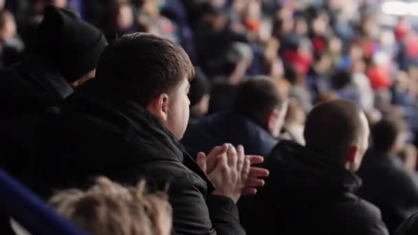 Man in black jacket watches hockey game on spectator places — Stock Video
