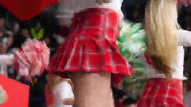 Mulheres de saias curtas vermelhas dançam com pompons no estádio — Vídeo de Stock