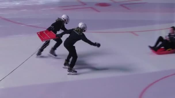 Hommes dans les casques lancent ventilateur de sport pour glisser le long de l'arène de glace — Video