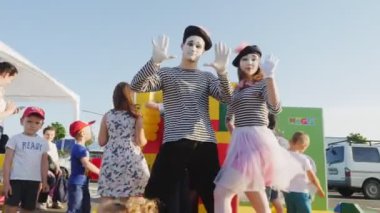 Pandomimist giysileri ve makyajlı oyuncular sokakta gösteri yapıyorlar.