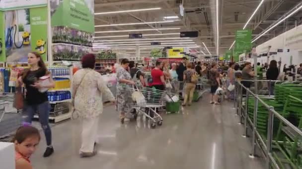 Rij klanten met winkelwagentjes in supermarkt — Stockvideo