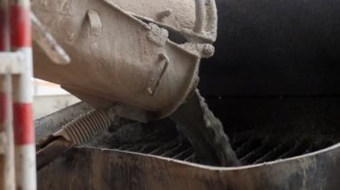 Kapalı alandaki depodan ıslak betonu konteynıra boşaltıyorlar.