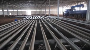Bitmemiş fabrika atölyesinde metal borular mavi kamyon vinci