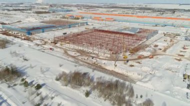 Karlı inşaat alanındaki atölyenin yanında metal leşler var.