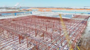 Vinç, karlı hava sahasındaki deponun metal iskeletinin yanında.