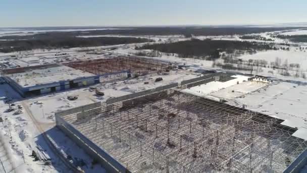 Gebäude mit Metallkarkasse auf offener schneebedeckter Baustelle — Stockvideo