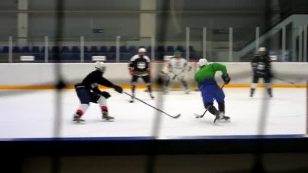 Idrottsmän i uniform och hjälmar spelar hockey på isarenan — Stockvideo