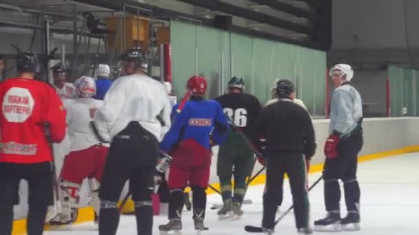 Homme joueur en uniforme patins le long de l'arène de glace brillamment éclairée — Video