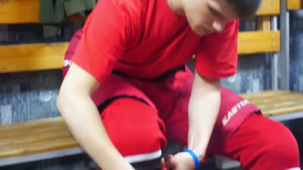 Hockey players lace skates preparing in dressing room — Stock Video