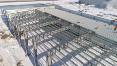 Karlı şantiyedeki işçi çatı fabrikası deposu