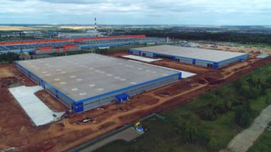 Üretim fabrikasının yanında düz çatıları olan depo binaları.