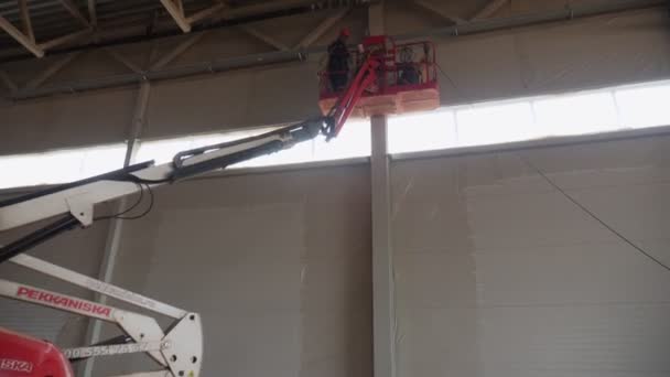 Elektrikere installerer kabel i taket på nytt lager – stockvideo