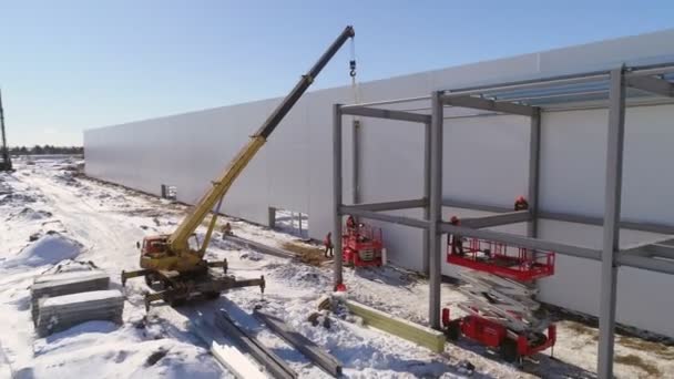 Camion grue près de l'entrepôt d'usine avec des constructeurs sur le toit — Video