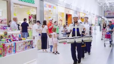 Müteahhit elbiseli müzisyenler alışveriş merkezinde davul çalarlar.