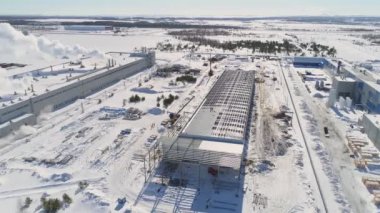 Metal leşler ve kışın çalışan işçilerle dolu bir depo.