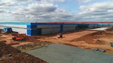 İşçiler tamamlanmamış binanın yakınına beton döşüyorlar