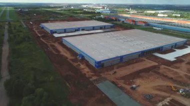 İnşaat alanında çatıları düz olan depo binaları.