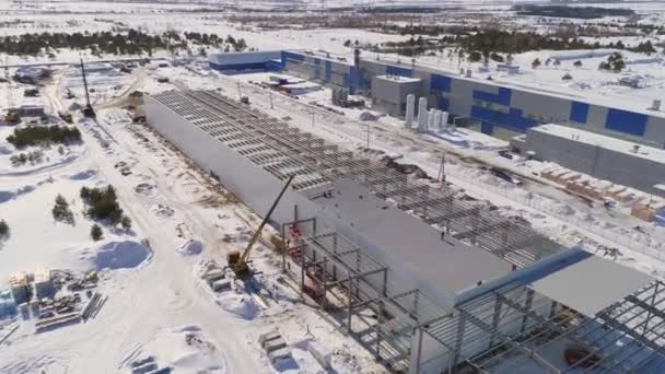 Employees work on roof and inside workshop carcass in winter — Stock Video