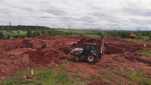Escavatore trasporta mucchio di sporcizia in secchio in cantiere — Video Stock
