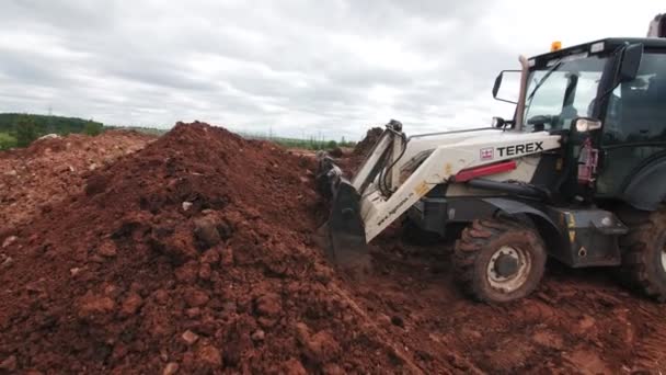 Buldozer bere nečistoty s kbelíkem na otevřeném staveništi — Stock video