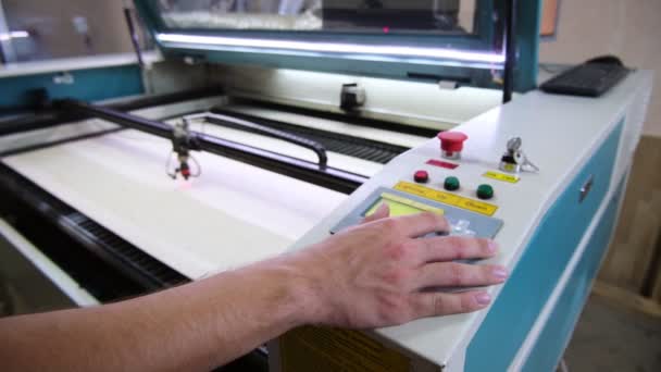 Zaměstnanec tiskne klávesy na ovládacím panelu plotru v typografii