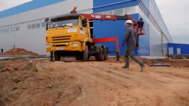 İşçiler beşikteki mavi atölye duvarı ile çalışıyorlar