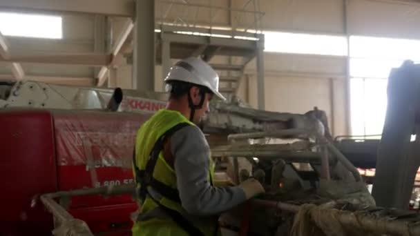 Robotnik stoi w podnoszeniu kołyski w pobliżu czerwonej ciężarówki w warsztacie — Wideo stockowe