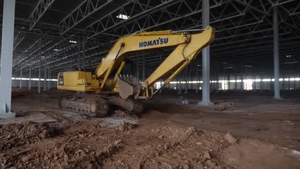 Large digger truck with bucket drives along built workshop — Stock Video