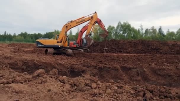 Camión excavadora hace con parte colgante en cubo cerca de trinchera — Vídeo de stock