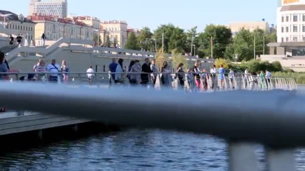 Menschen lehnen an Metallgeländer und blicken auf Fluss an Böschung — Stockvideo