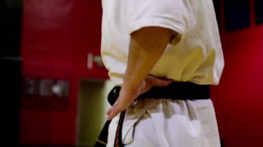 Spor salonunda antrenman yapmadan önce beyaz kimonolu bir dövüşçü.